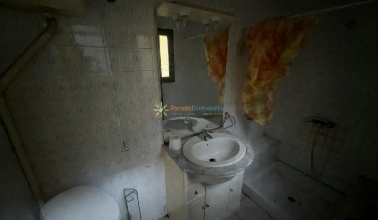 Baño antiguo con cortina colorida