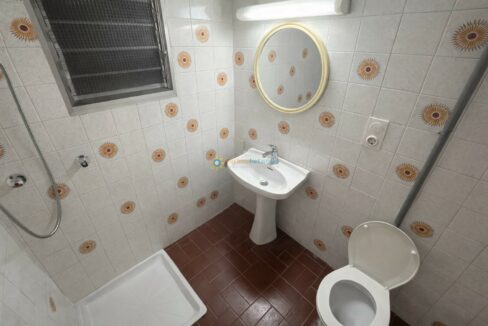 Baño compacto con detalles en naranja (1)