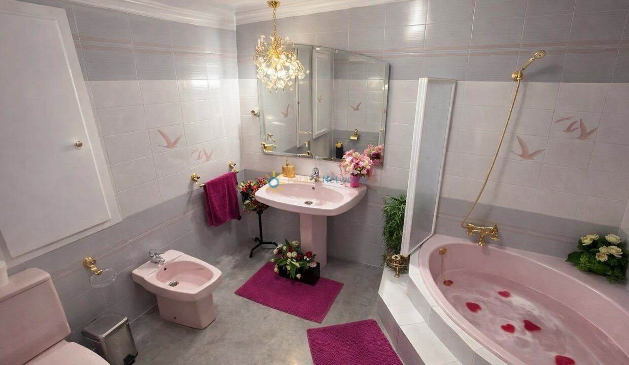 Baño elegante en tonos rosa y dorado
