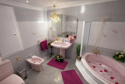 Baño elegante en tonos rosa y dorado