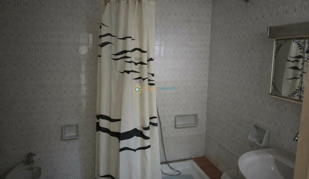 Baño luminoso con cortina de ducha