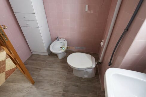 Baño moderno con azulejos rosas y madera