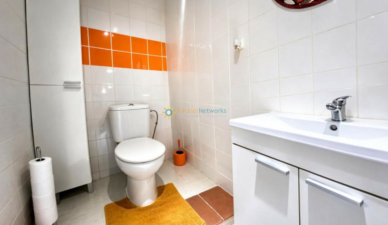 Baño moderno y luminoso con detalles naranjas