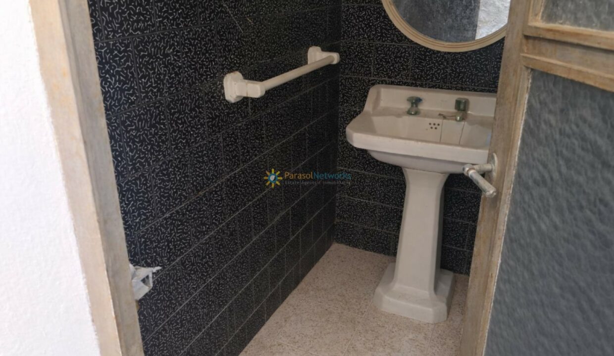 Baño pequeño con azulejos negros