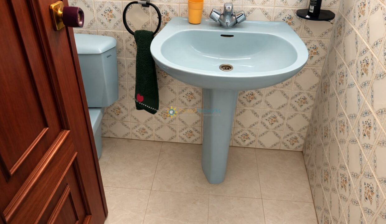 Baño pequeño y ordenado con detalle retro
