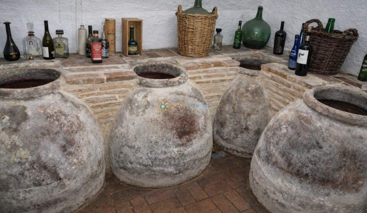 Bodega rústica con tinajas y botellas