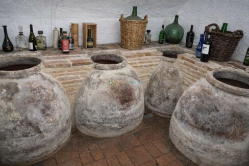 Bodega rústica con tinajas y botellas