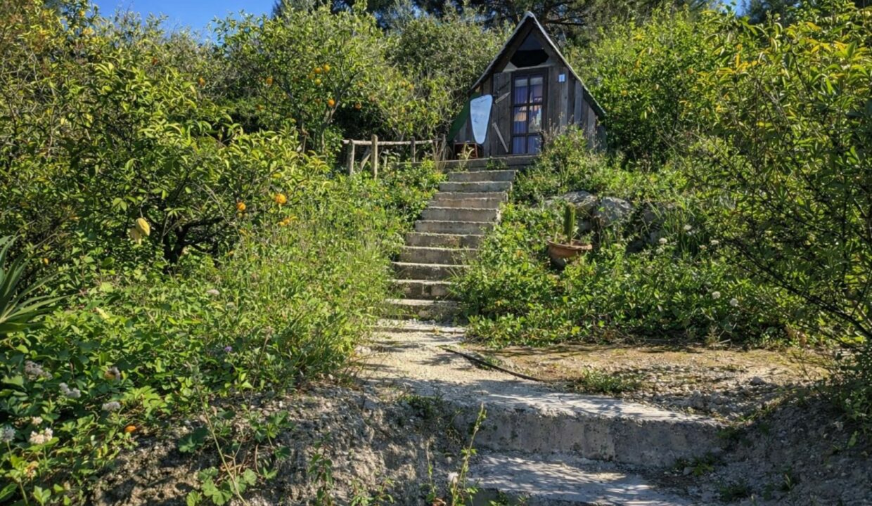 Cabaña rústica entre piedras y naturaleza