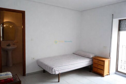 Cama ordenada en habitación luminosa