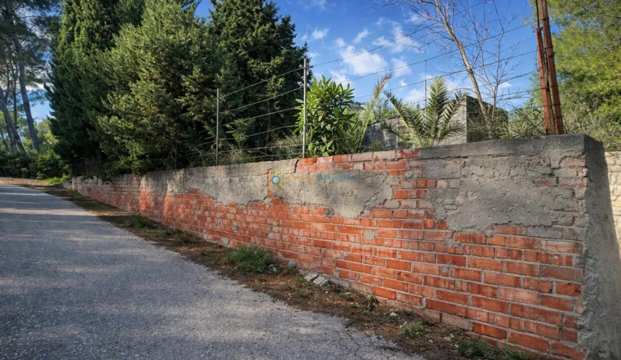 Camino curvado junto a muro antiguo
