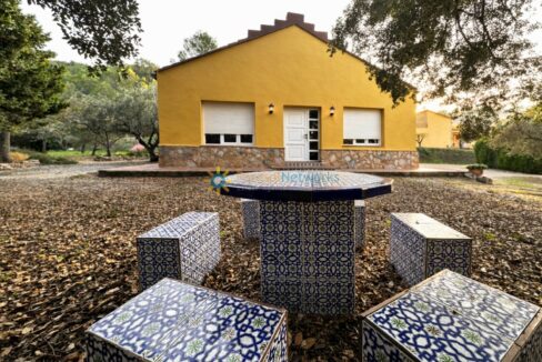 Casa amarilla en el jardín rural