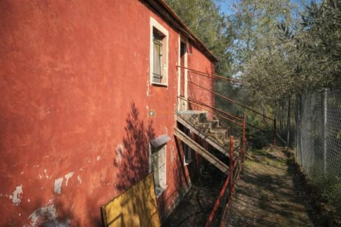 Casa roja envejecida entre arboledas