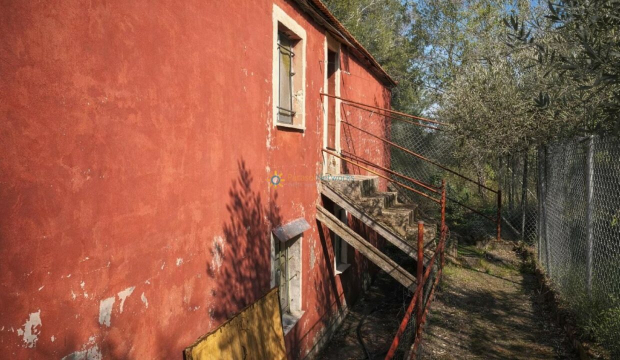Casa roja envejecida entre arboledas
