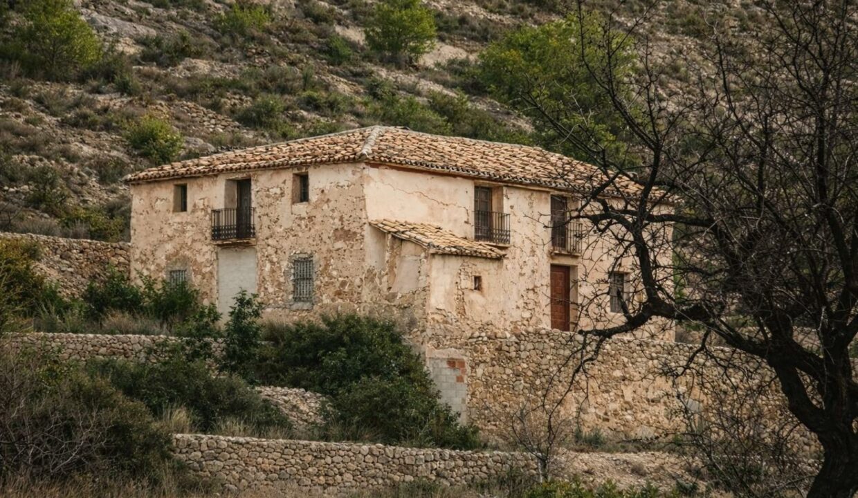 Casa rural envejecida en paisaje rocoso