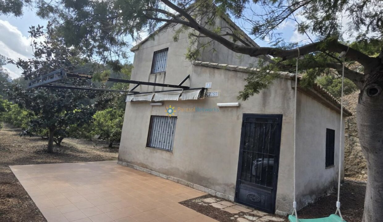 Casa rústica con columpio en la sombra