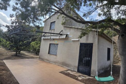 Casa rústica con columpio en la sombra