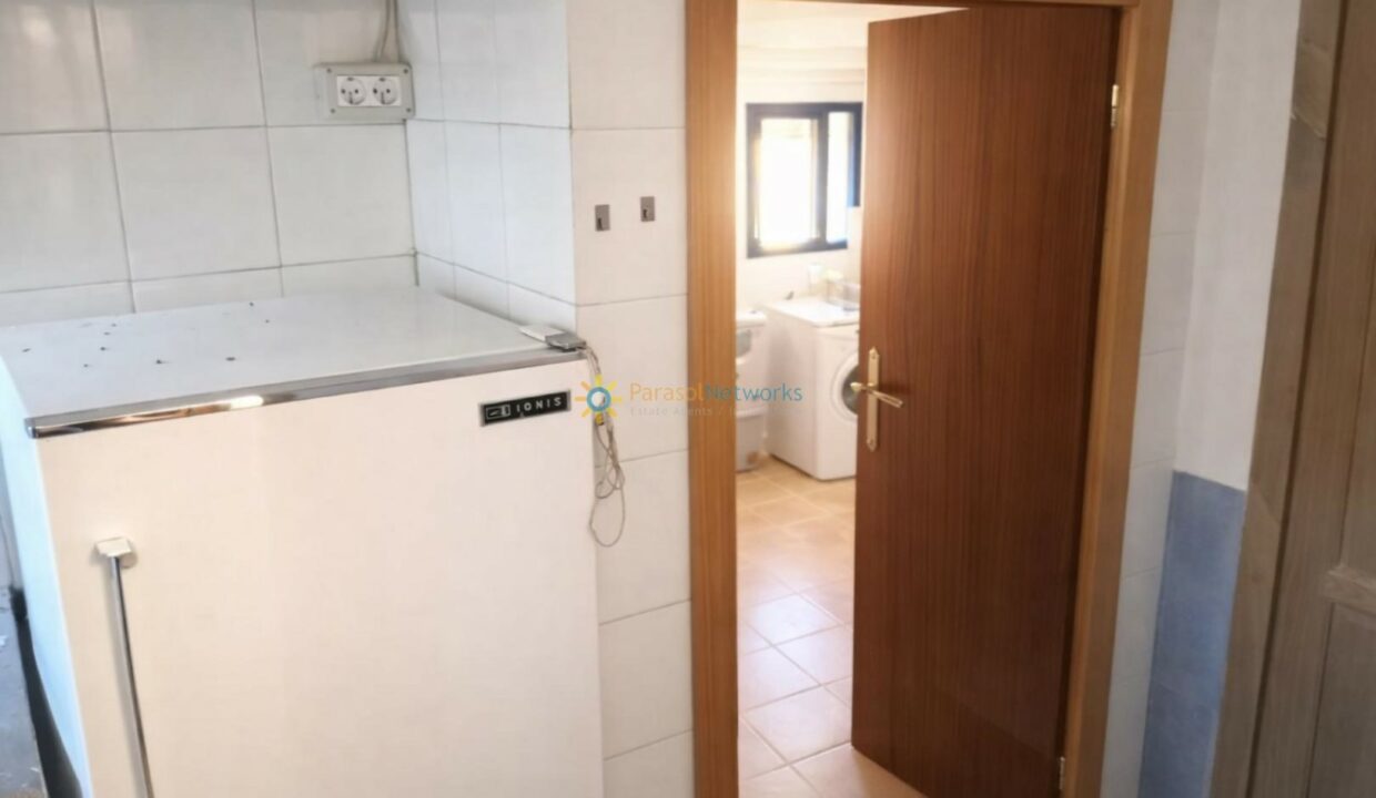 Cocina con frigorífico y puerta de madera