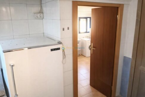 Cocina con frigorífico y puerta de madera