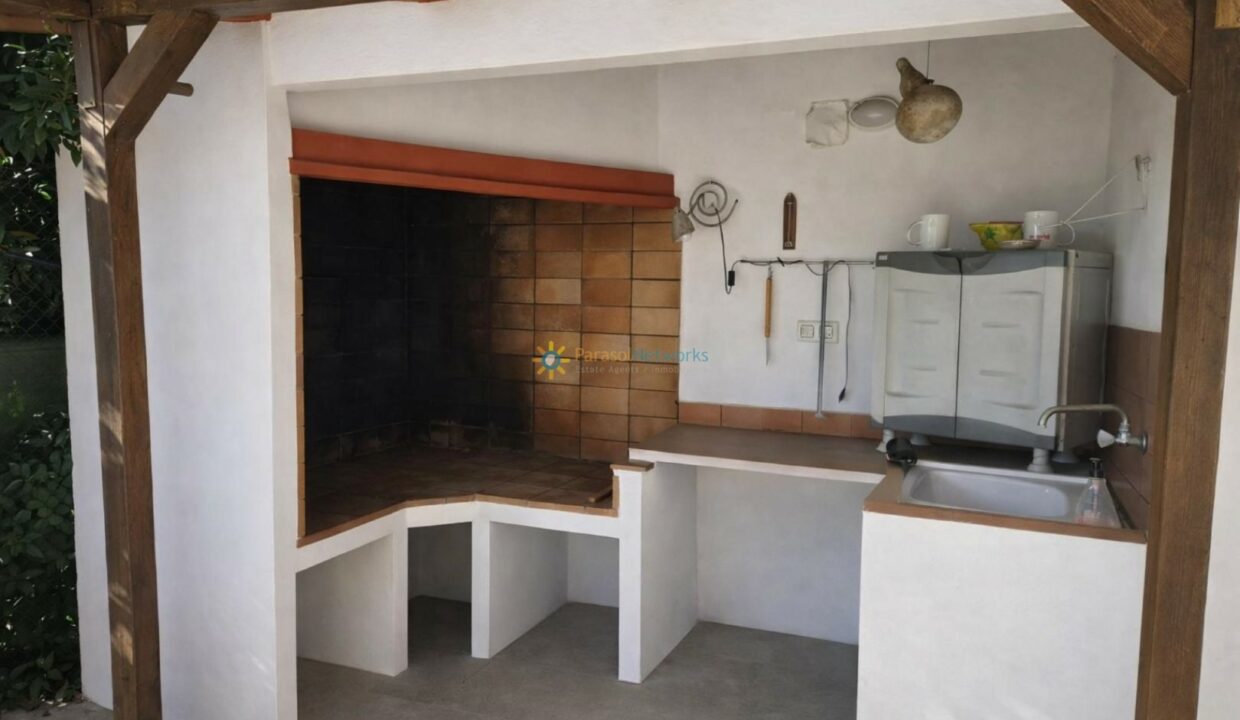Cocina exterior con parrilla y lavabo