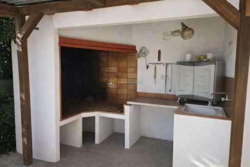 Cocina exterior con parrilla y lavabo