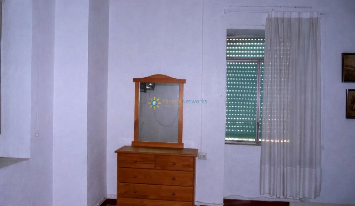 Cómoda de madera junto al espejo