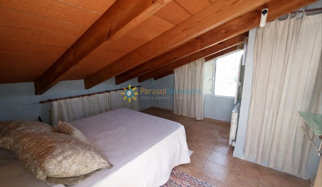 Dormitorio en ático con detalles cálidos