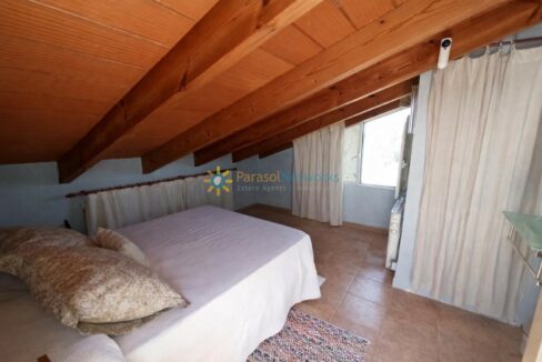 Dormitorio en ático con detalles cálidos