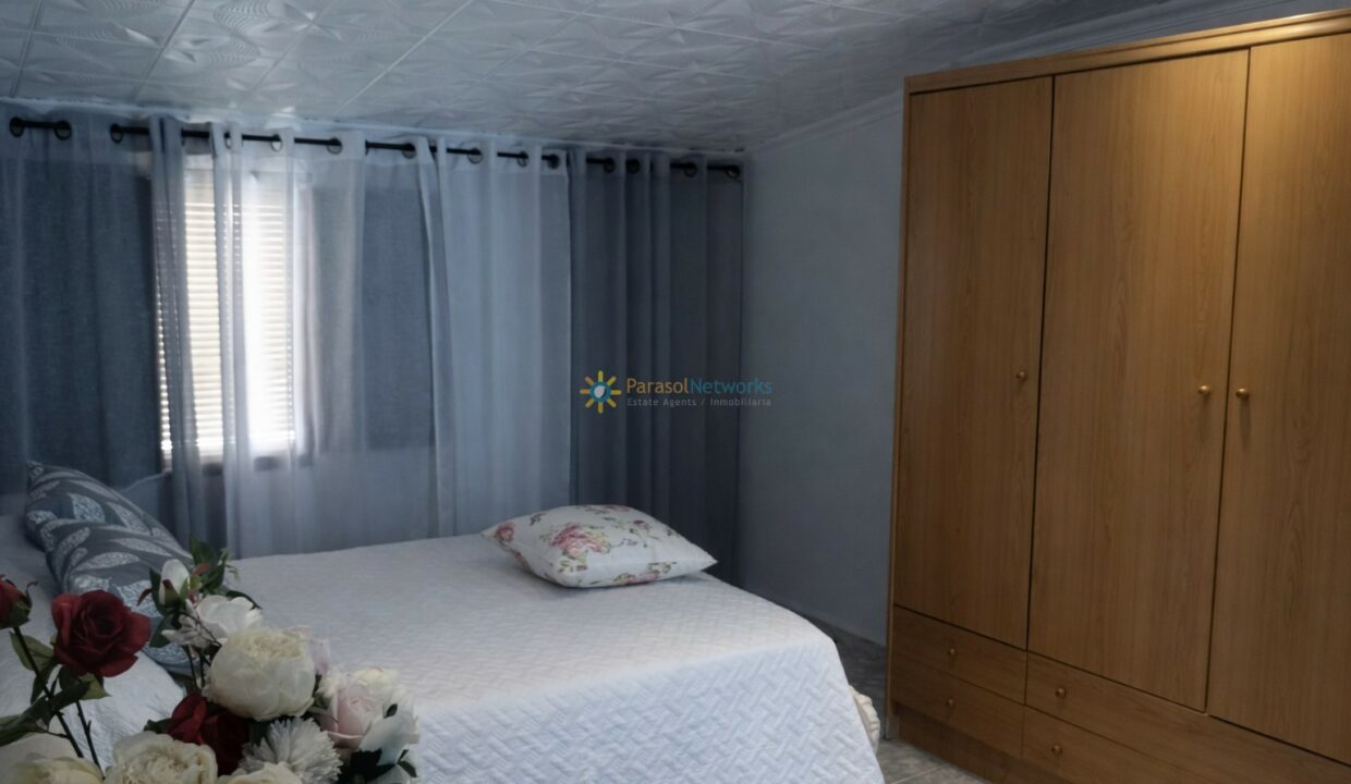 Dormitorio luminoso con flores y muebles