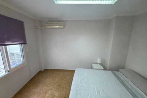 Dormitorio minimalista con detalles morados
