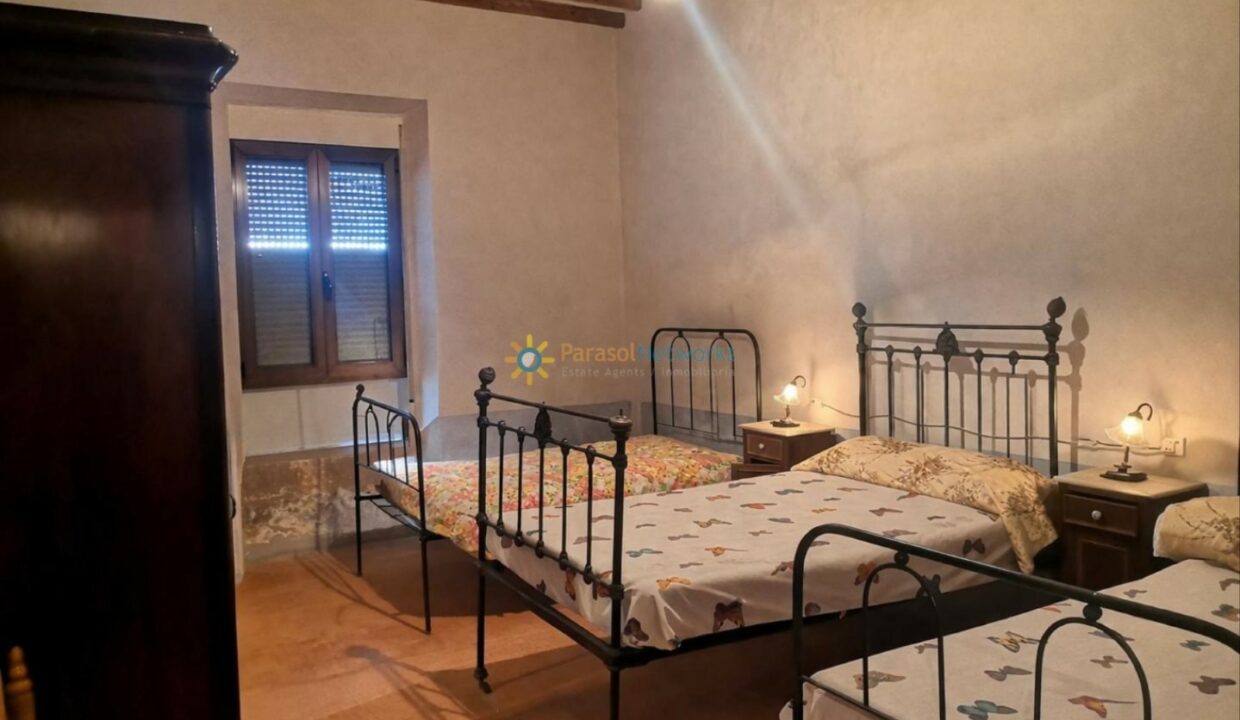 Dormitorio rústico cálido con camas de hierro