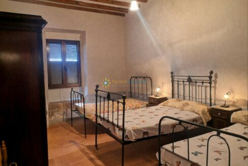 Dormitorio rústico cálido con camas de hierro