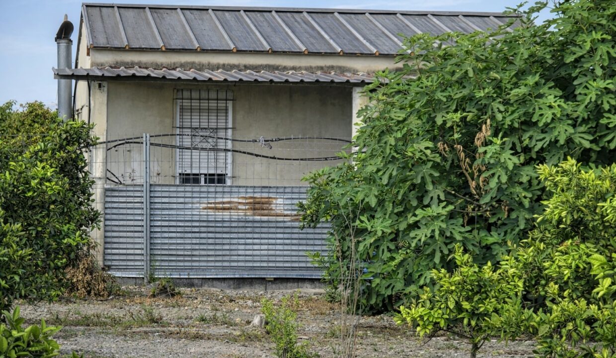 Edificio rústico con jardín y cerca