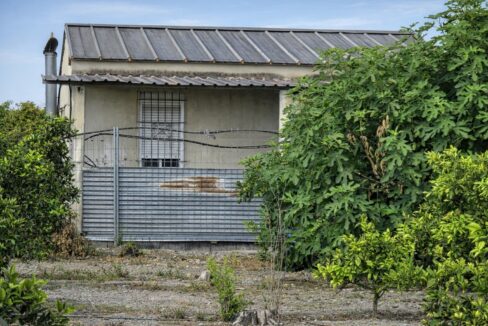 Edificio rústico con jardín y cerca