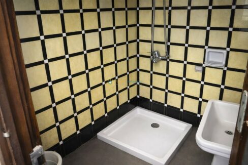 Esquina de baño con azulejos amarillos