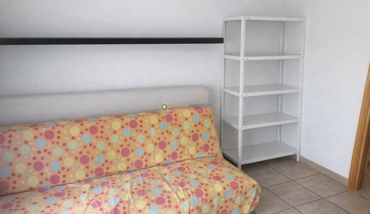 Esquina luminosa con sofá y estantería