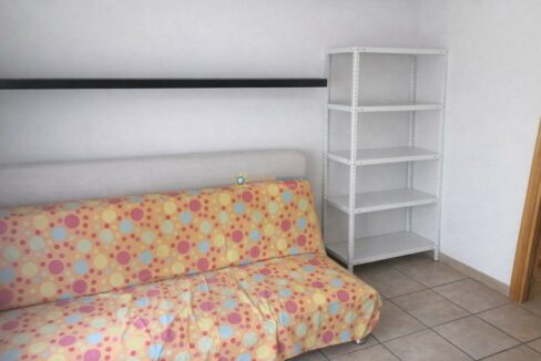 Esquina luminosa con sofá y estantería