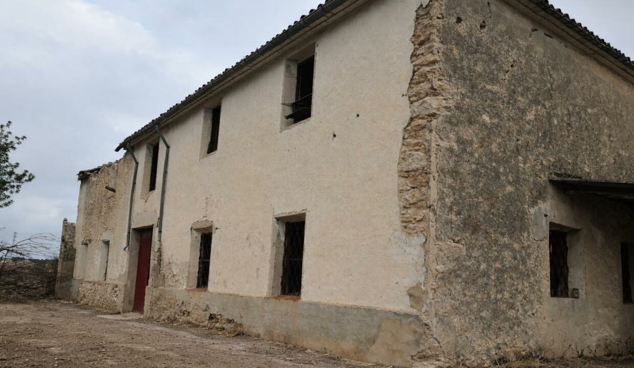 Granja abandonada bajo cielo nublado