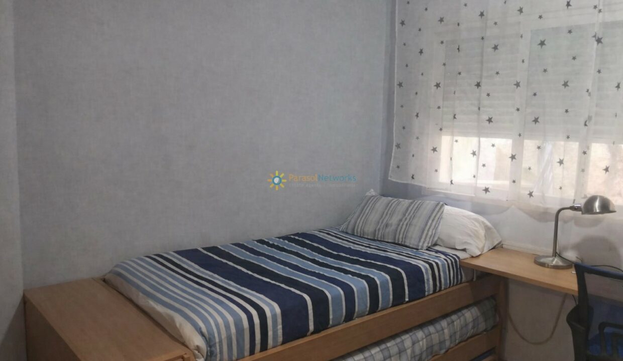 Habitación ordenada con cama y escritorio