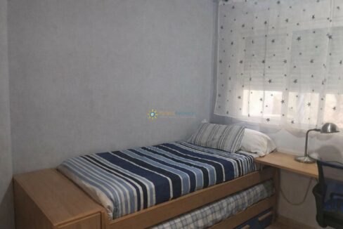 Habitación ordenada con cama y escritorio