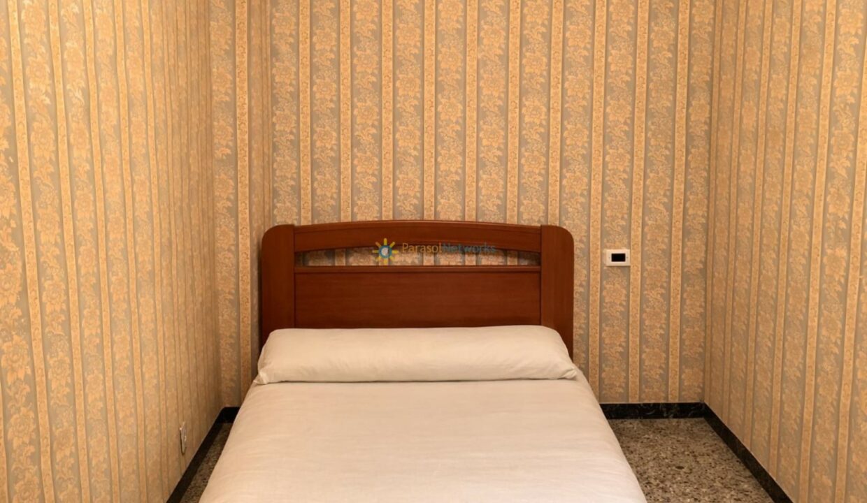 Habitación pequeña con cabecero de madera