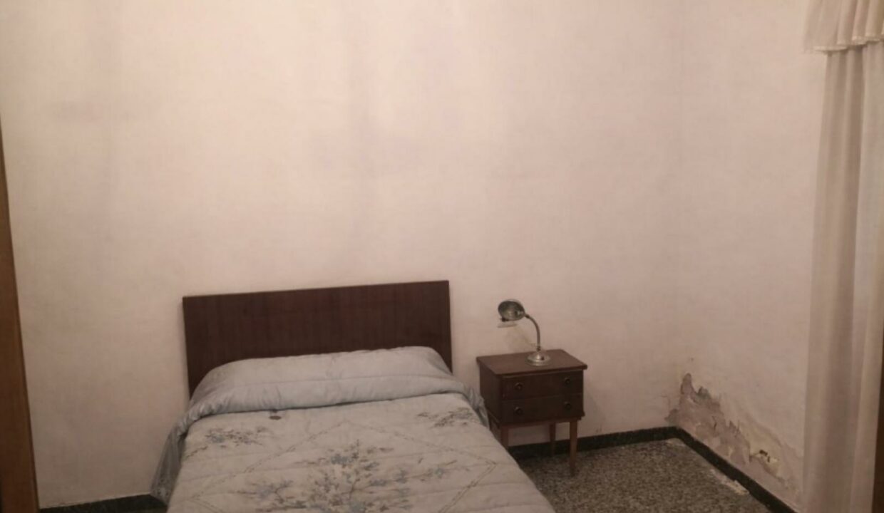 Habitación sencilla con pared dañada