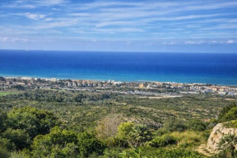 Paisaje costero con vegetación y pueblo