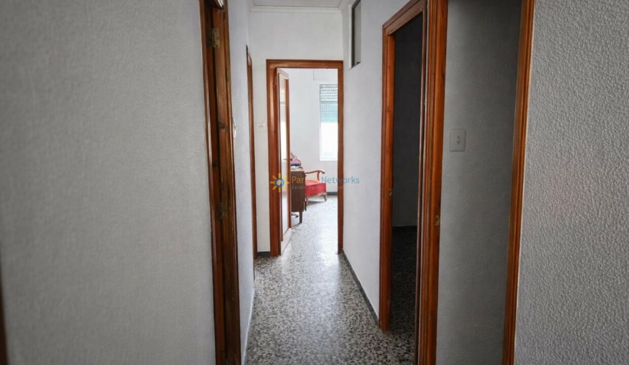 Pasillo con puerta abierta al dormitorio