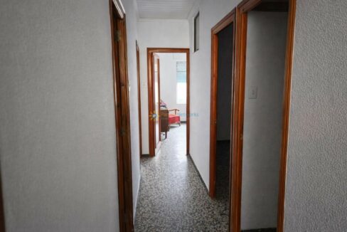 Pasillo con puerta abierta al dormitorio