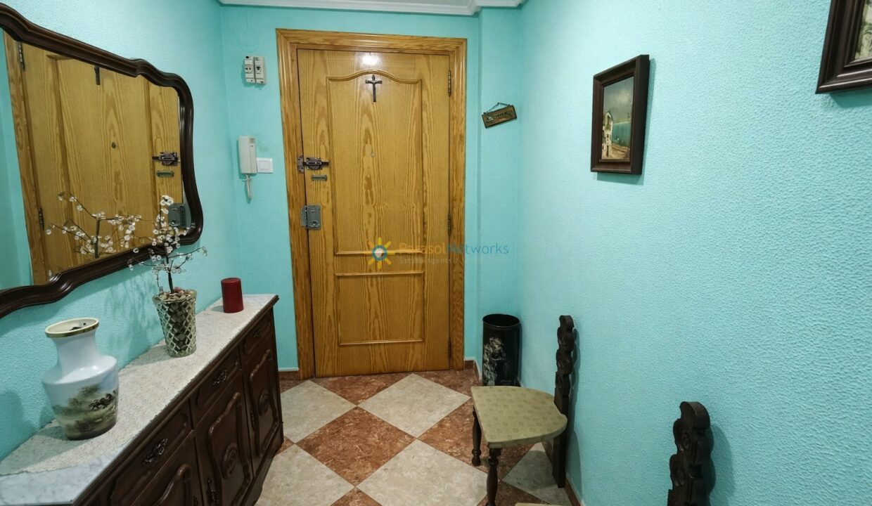 Pasillo con puerta de madera decorada