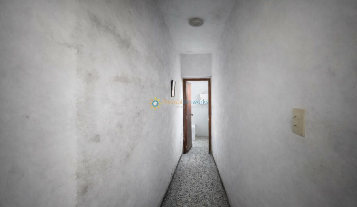 Pasillo envejecido con puerta abierta