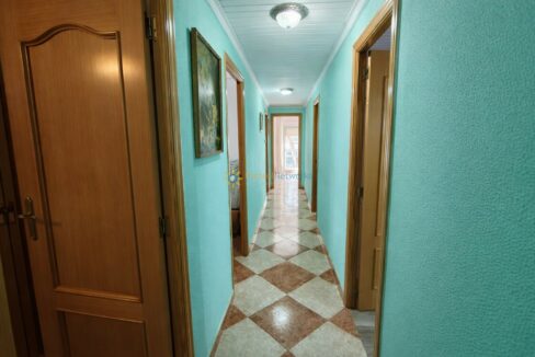 Pasillo iluminado con puertas de madera