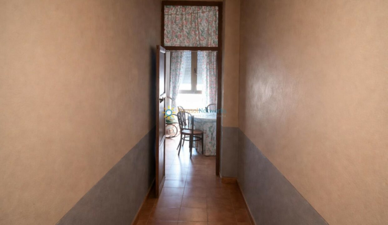 Pasillo iluminado hacia la cocina