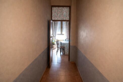 Pasillo iluminado hacia la cocina