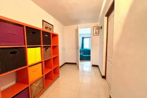 Pasillo luminoso con unidad de almacenamiento naranja